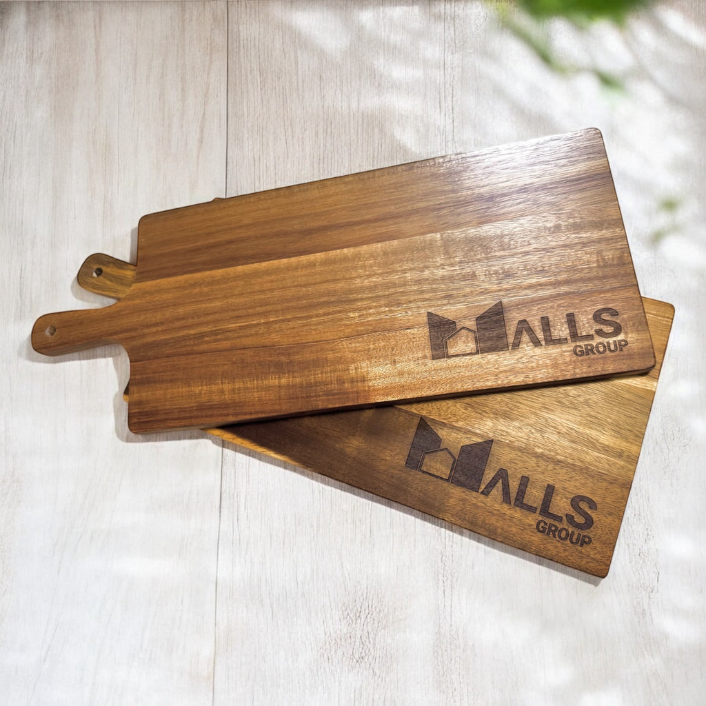 Two stacked engraved acacia serving boards showing grain detail and branding