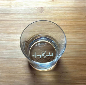 Whiskey glass placed on wooden surface personalised with name.
