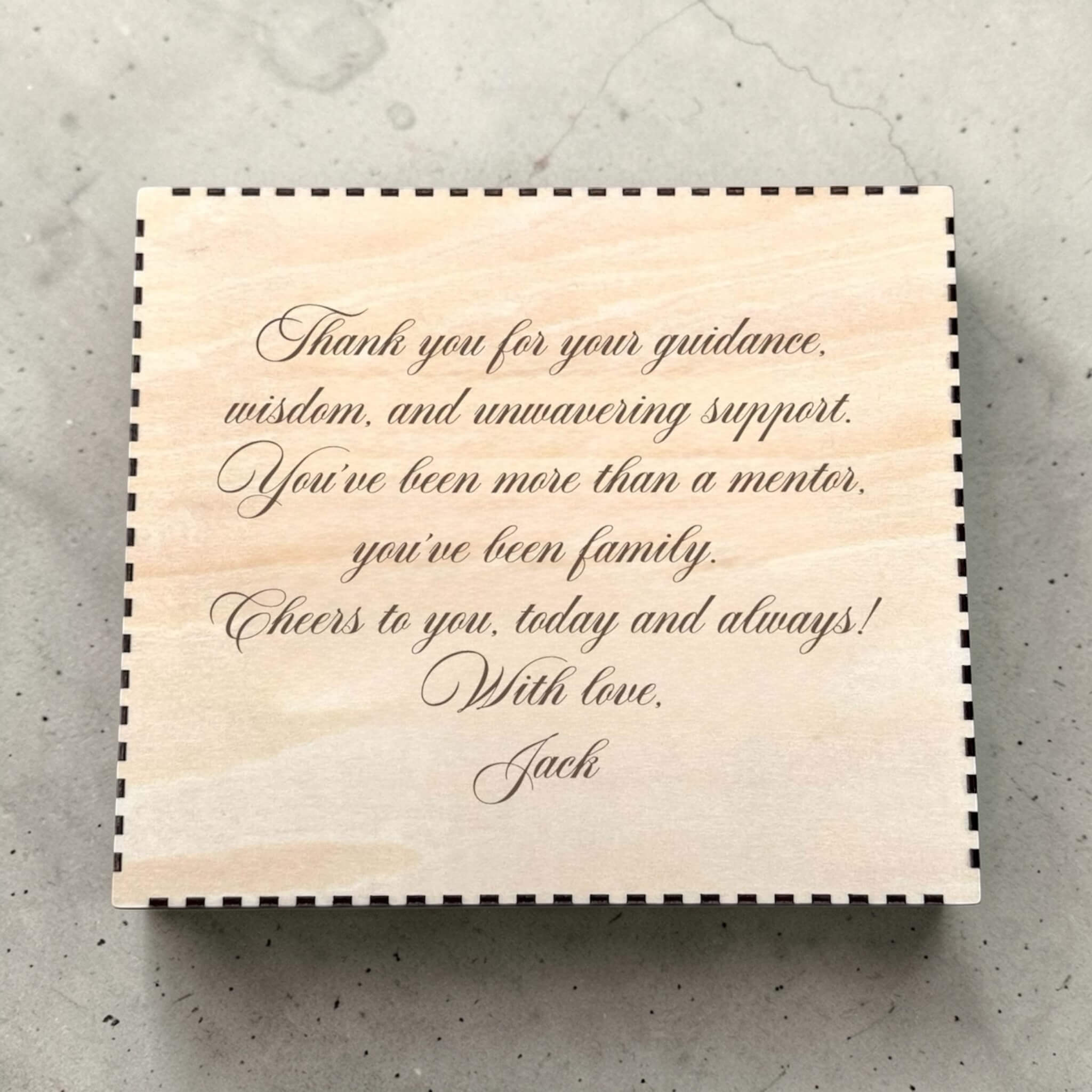 Wooden box with engraved message for godfather on a textured surface