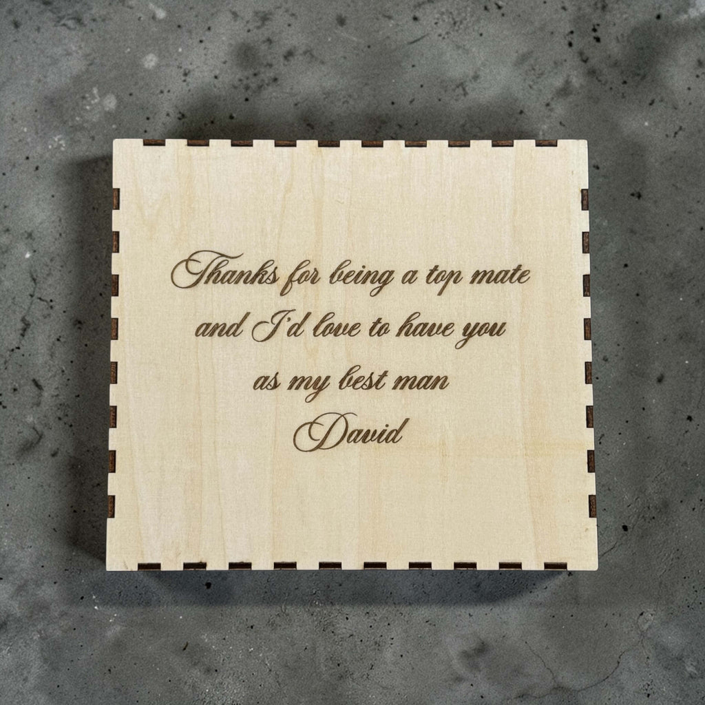 Wooden box with engraved with personalised text on a gray surface
