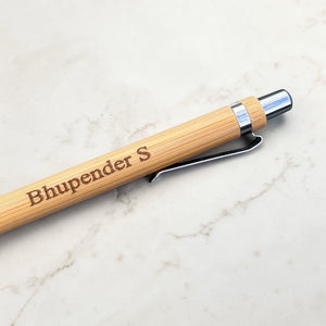 Wooden pen with engraved name on a marble surface