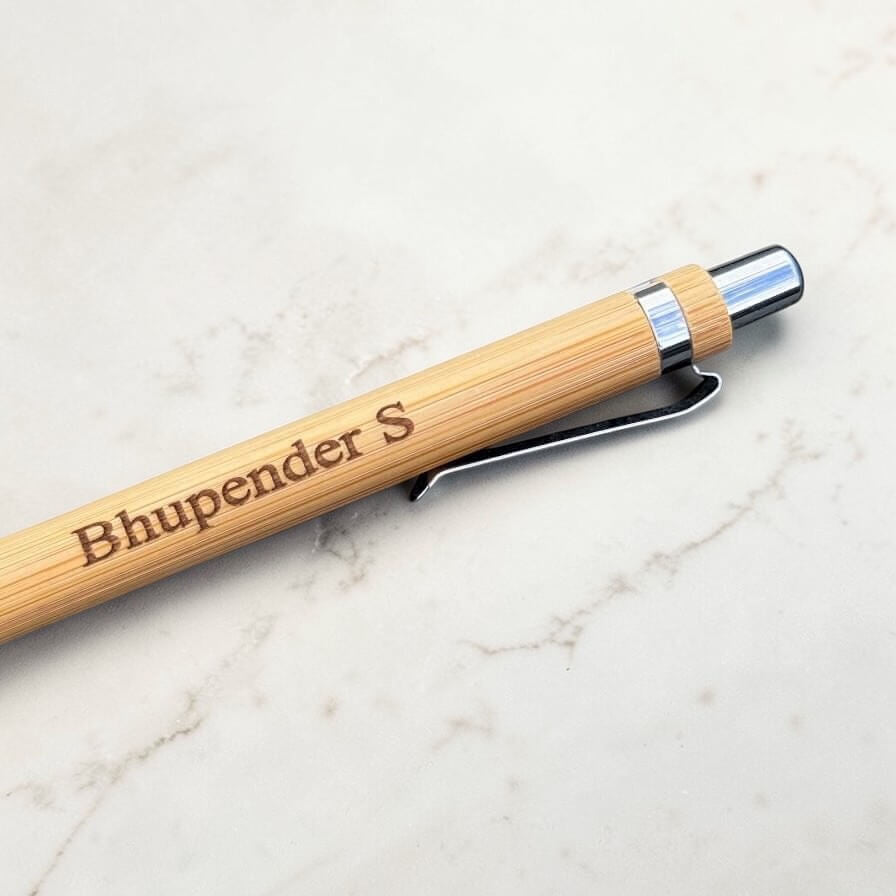 Wooden pen with engraved name on a marble surface