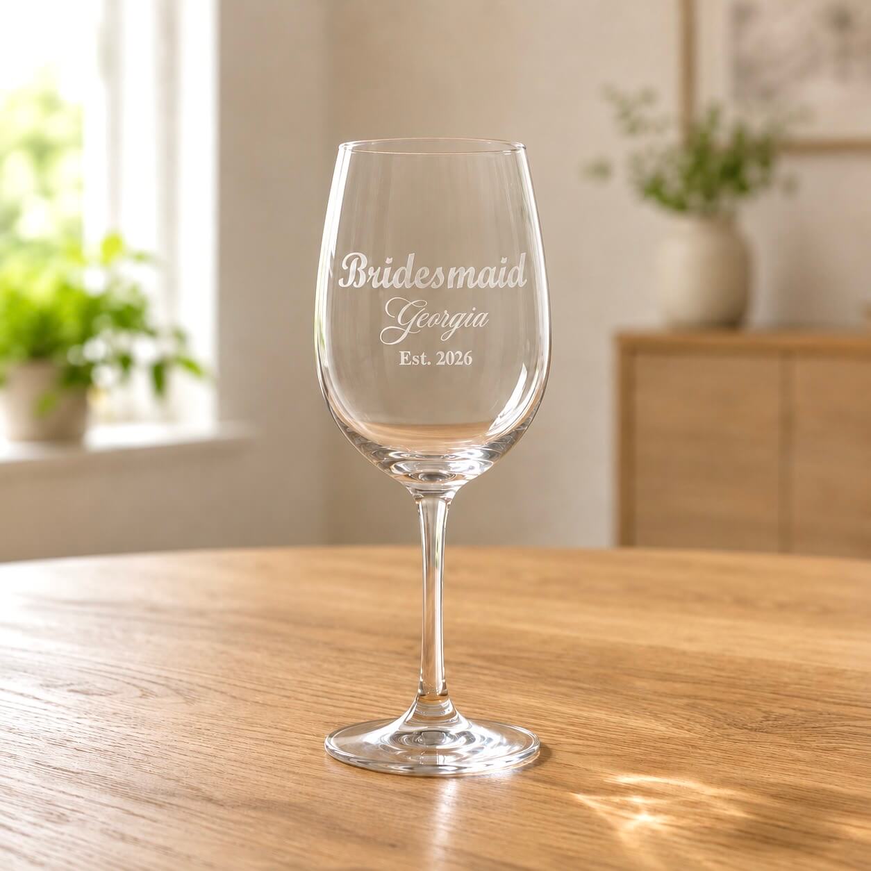 Clear wine glass with frosted bridesmaid Georgia engraving on wooden table