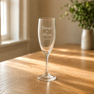Close up engraved bridal party champagne glass with names date and heart detail