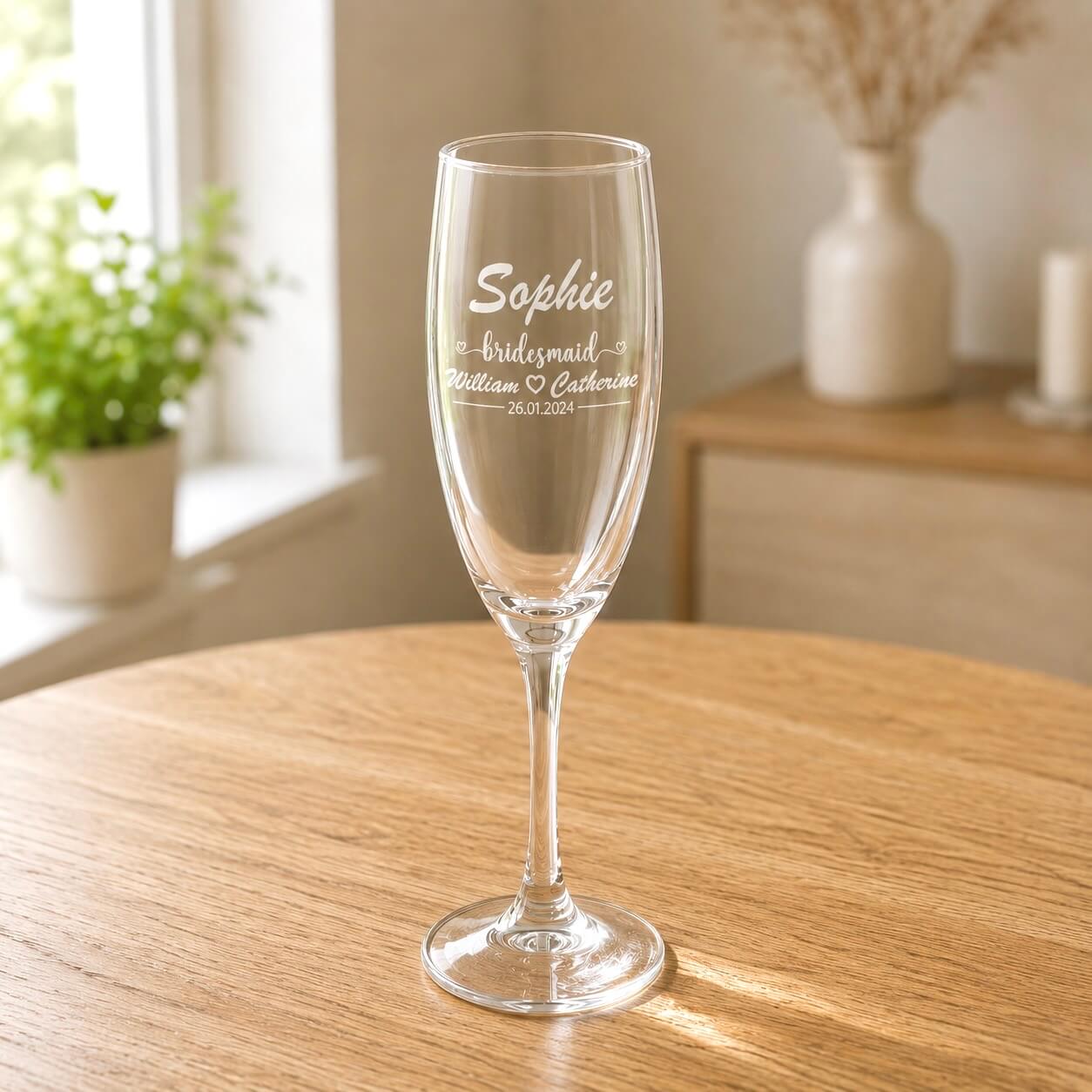 Close up engraved bridesmaid champagne glass with Sophie name and wedding date