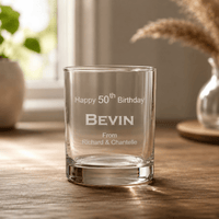 Engraved birthday whiskey glass with Bevin 50th birthday message on wooden table