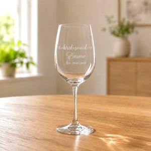 Engraved bridesmaid wine glass with Emma name and wedding date in warm home setting